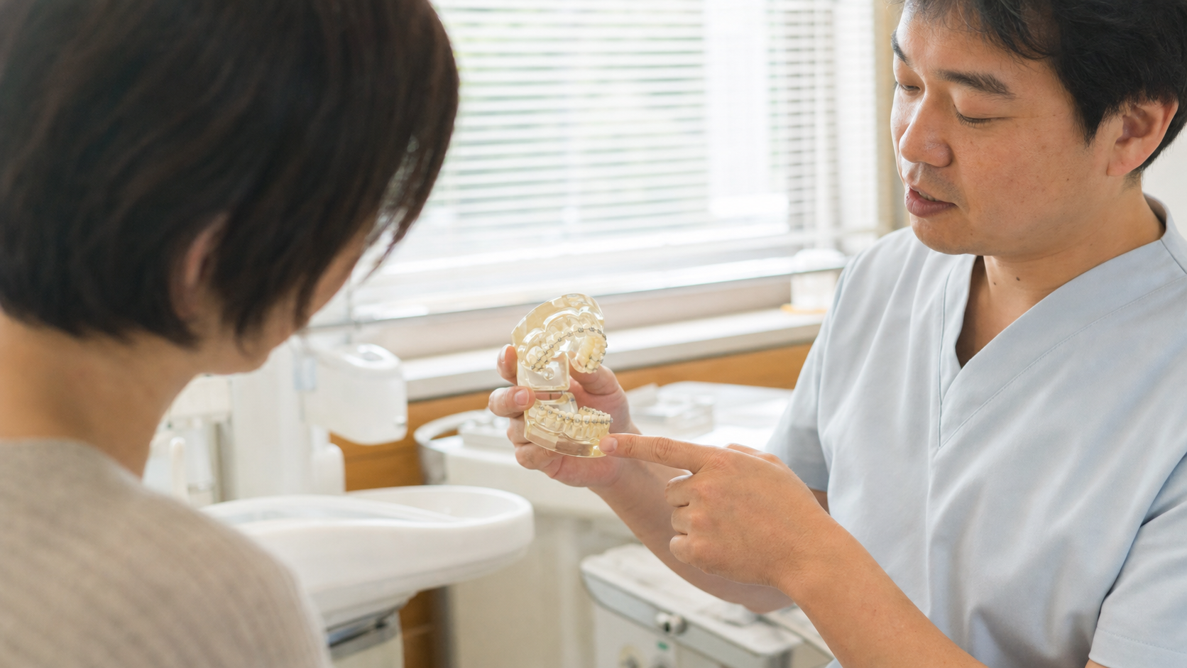 歯科医師が歯列模型を使って矯正治療について説明する様子